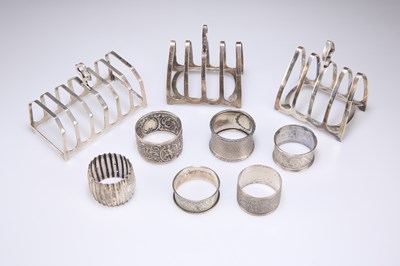 Lot 329 - THREE GEORGE V SILVER TOAST RACKS AND SIX SILVER NAPKIN RINGS