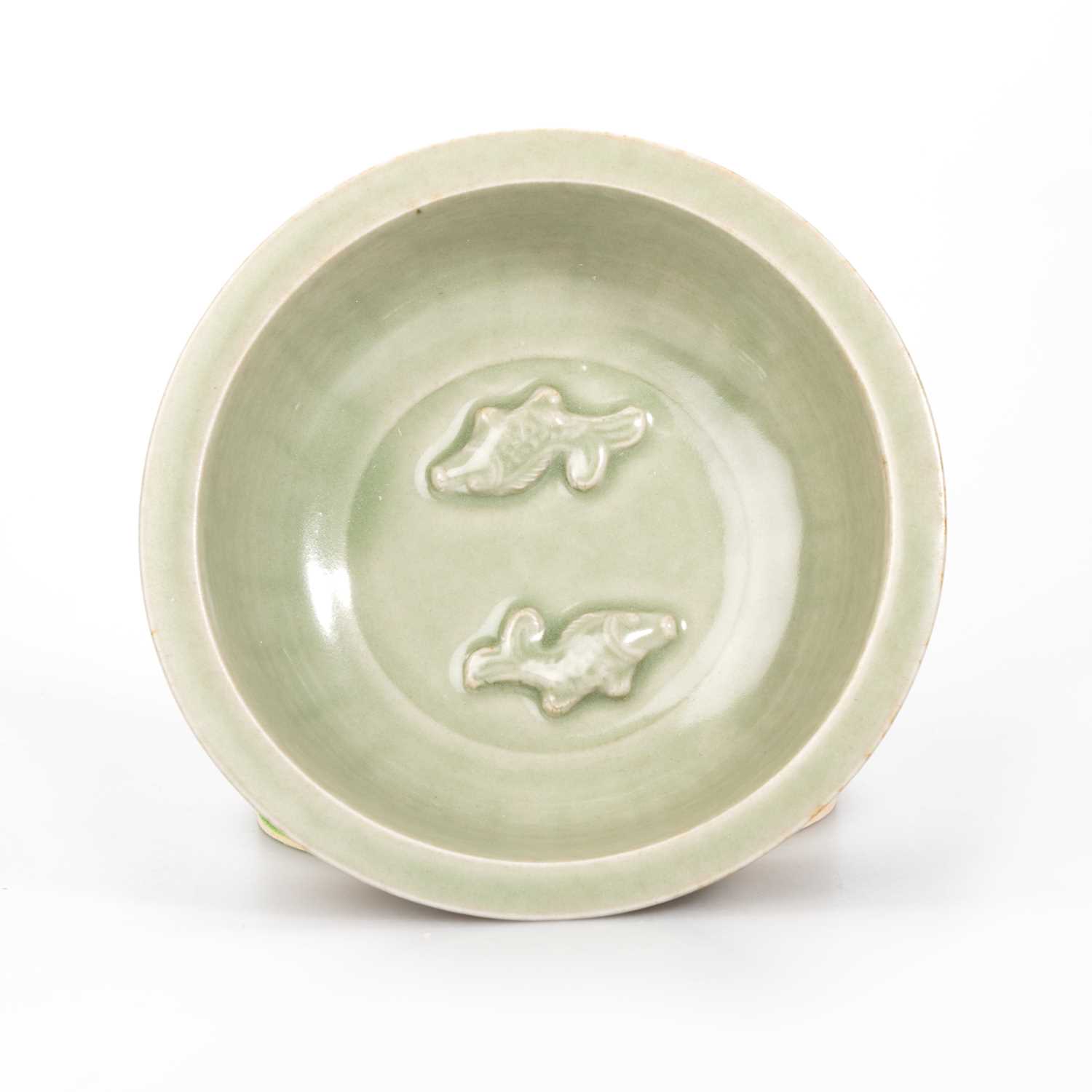 Lot 87 - A CHINESE MOULDED CELADON TWIN-FISH BOWL