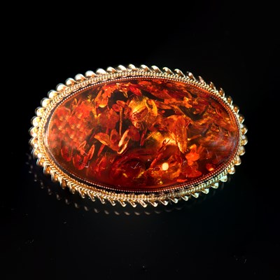 Lot 590 - A 9 CARAT YELLOW GOLD AND AMBER OVAL BROOCH