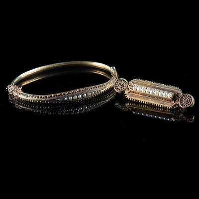 Lot 611 - A LATE VICTORIAN 15 CARAT YELLOW GOLD AND SEED PEARL HINGED BANGLE