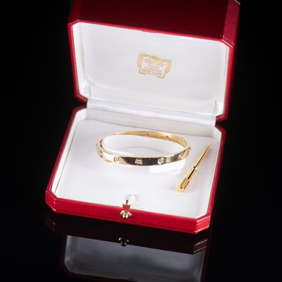 Lot 605 - A CARTIER 18 CARAT GOLD AND DIAMOND LOVE BANGLE WITH BOX AND CERTIFICATION