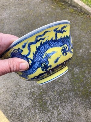 Lot 121 - A CHINESE MING STYLE YELLOW-GROUND BLUE AND WHITE 'DRAGON' BOWL