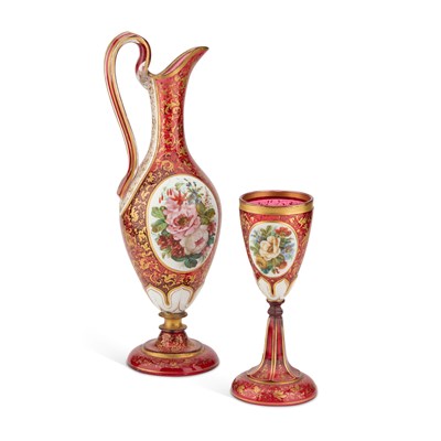 Lot 30 - A 19TH CENTURY BOHEMIAN GILDED AND PAINTED RUBY GLASS EWER AND GOBLET