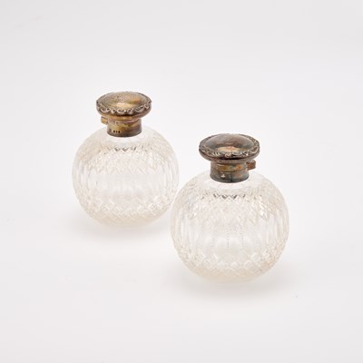 Lot 739 - A PAIR OF GEORGE V SILVER-TOPPED CUT-GLASS SCENT BOTTLES