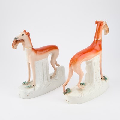 Lot 63 - A NEAR PAIR OF VICTORIAN STAFFORDSHIRE POTTERY MODELS OF GREYHOUNDS