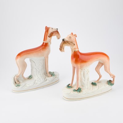 Lot 63 - A NEAR PAIR OF VICTORIAN STAFFORDSHIRE POTTERY MODELS OF GREYHOUNDS