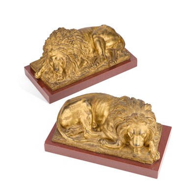 Lot A HANDSOME PAIR OF MID-19TH CENTURY BRONZE MODELS OF RECUMBENT LIONS