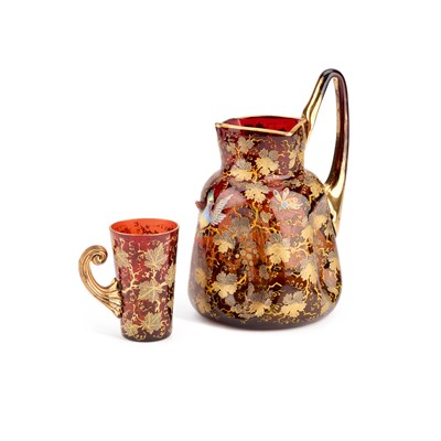 Lot 15 - A MOSER GILT AND ENAMELLED AMBERLINE GLASS PITCHER AND BEAKER, EARLY 20TH CENTURY