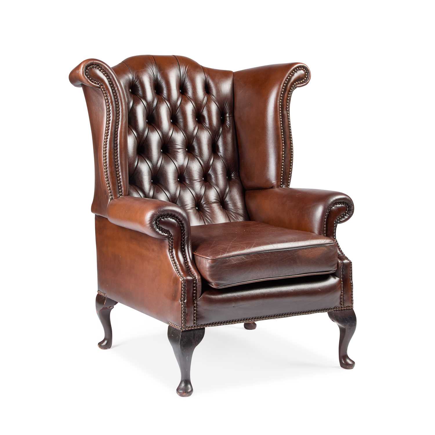 Lot A BROWN LEATHER UPHOLSTERED WING-BACK ARMCHAIR