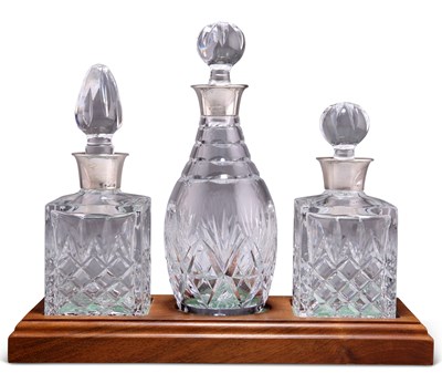 Lot 1208A - A SET OF THREE SILVER-MOUNTED CUT-GLASS DECANTERS