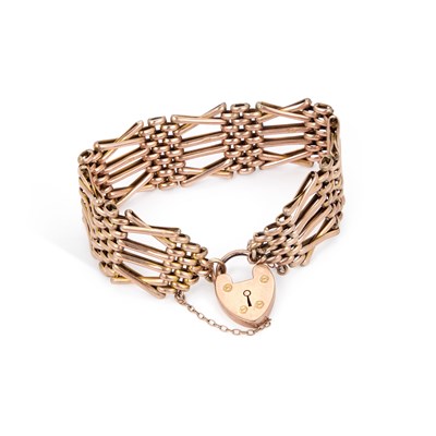 Lot 591 - A BROAD GATE LINK BRACELET WITH A HEART PADLOCK CLASP