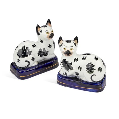 Lot 55 - A PAIR OF VICTORIAN STAFFORDSHIRE POTTERY MODELS OF RECUMBENT CATS