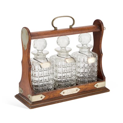 Lot 701 - A LATE VICTORIAN SILVER-PLATE MOUNTED OAK THREE-BOTTLE TANTALUS