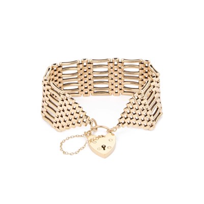 Lot 453 - A 9 CARAT GOLD BROAD GATE LINK BRACELET WITH HEART PADLOCK CLASP