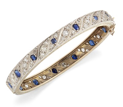 Lot 1640 - AN EARLY 20TH CENTURY SAPPHIRE AND DIAMOND HINGE OPENING BANGLE