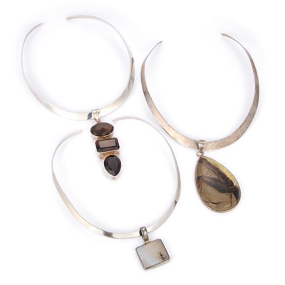 Lot 736 - THREE TORQUE NECKLACES WITH GEM-SET PENDANTS