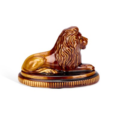 Lot 69 - A 19TH CENTURY TREACLE-GLAZED POTTERY MODEL OF A LION