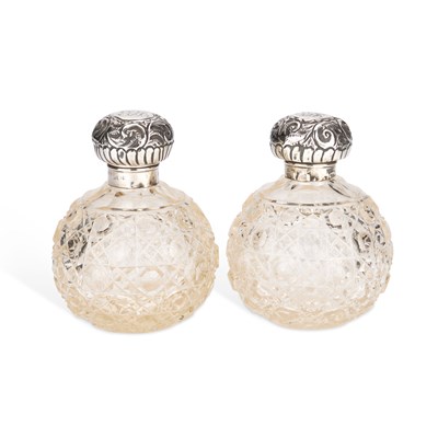 Lot 418 - A PAIR OF EDWARDIAN SILVER-TOPPED CUT-GLASS SCENT BOTTLES