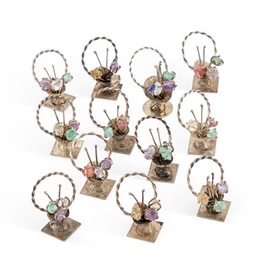Lot A SET OF TWELVE SILVER AND 'JEWELLED' MENU HOLDERS