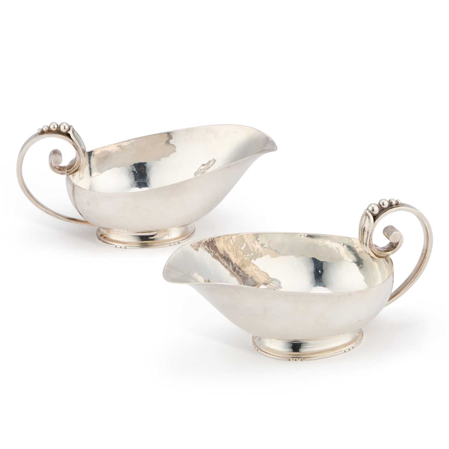 Lot 374 - A PAIR OF ARTS AND CRAFTS SILVER SAUCEBOATS