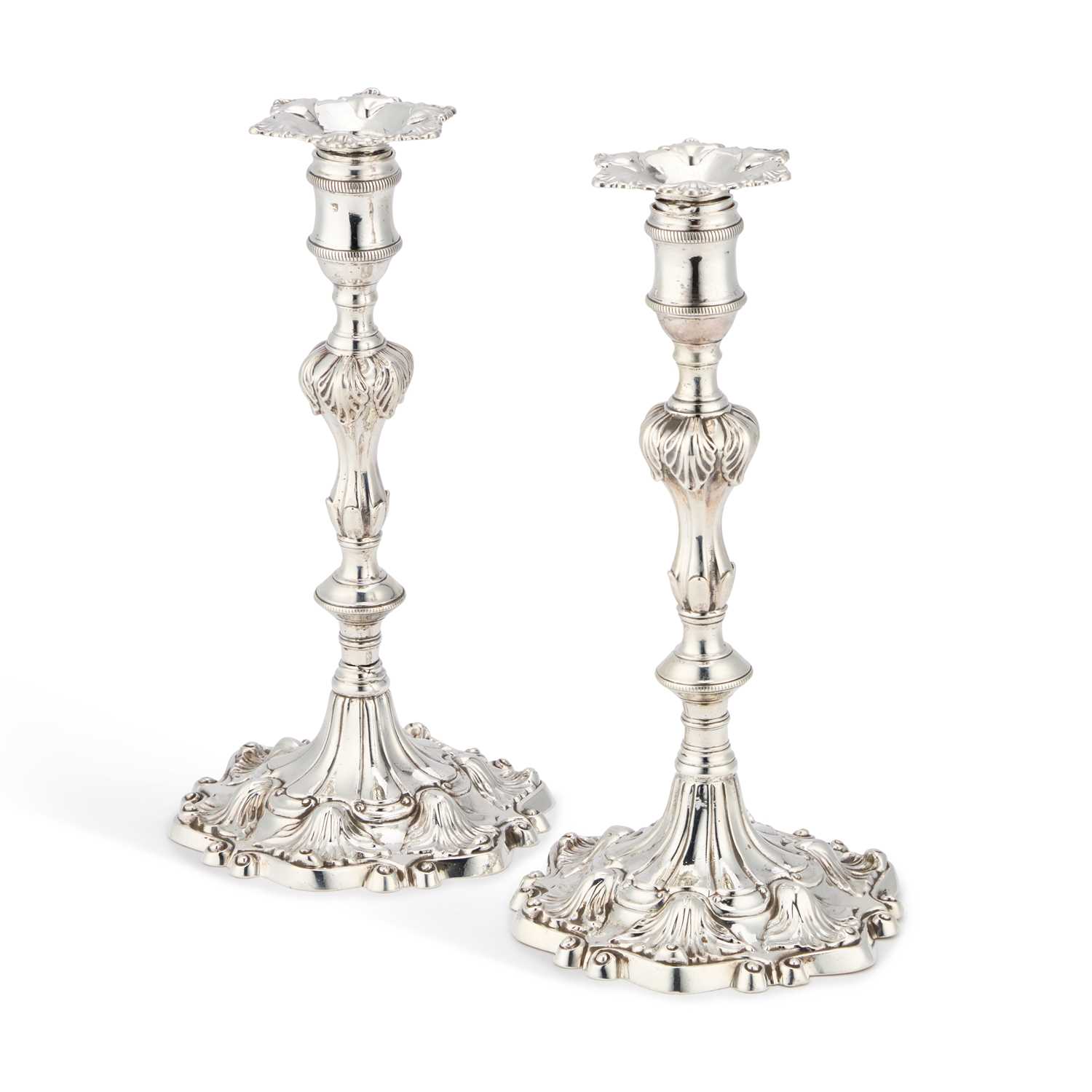 Lot A PAIR OF GEORGE II CAST SILVER CANDLESTICKS