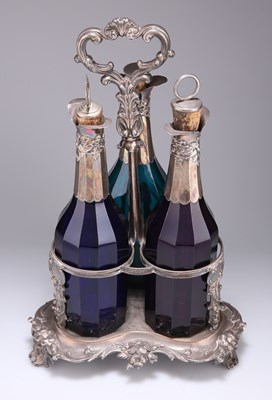 Lot 1013 - AN EARLY VICTORIAN SILVER-PLATED DECANTER STAND WITH THREE SILVER-MOUNTED COLOURED GLASS DECANTERS