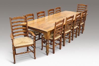 Lot 423 - A LARGE COUNTRY PINE DINING TABLE AND TEN OAK AND RUSH-SEATED LADDERBACK DINING CHAIRS