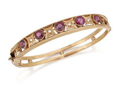 Lot 2036 - AN EARLY 20TH CENTURY 9 CARAT GOLD GARNET AND DIAMOND BANGLE