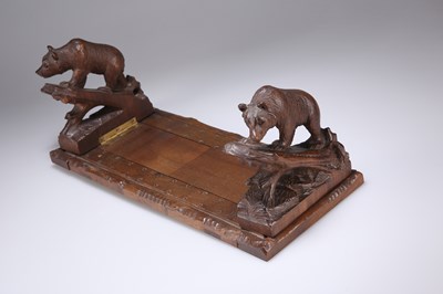 Lot 1343 - A LATE 19TH CENTURY BLACK FOREST CARVED BEAR BOOK SLIDE